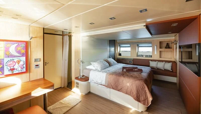 a bedroom with a bed and a desk aboard EL DISPARO Yacht for Sale