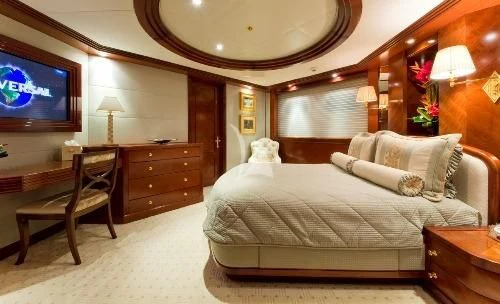 a hotel room with a bed and a television aboard BLUE MOON Yacht for Charter