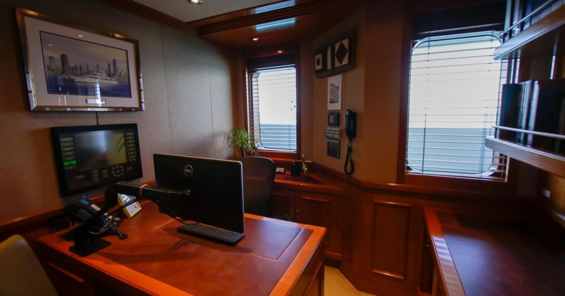 a room with a desk and a tv on the wall aboard BLUE MOON Yacht for Charter