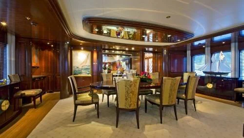 a room with a table chairs and a window aboard BLUE MOON Yacht for Charter