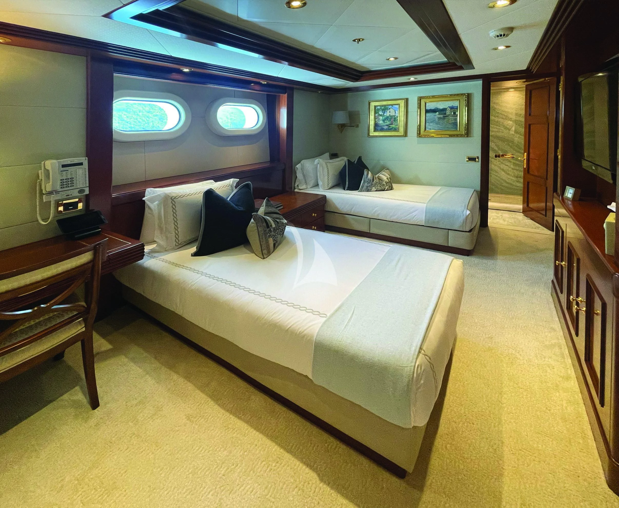 a room with a bed and a television aboard BLUE MOON Yacht for Charter