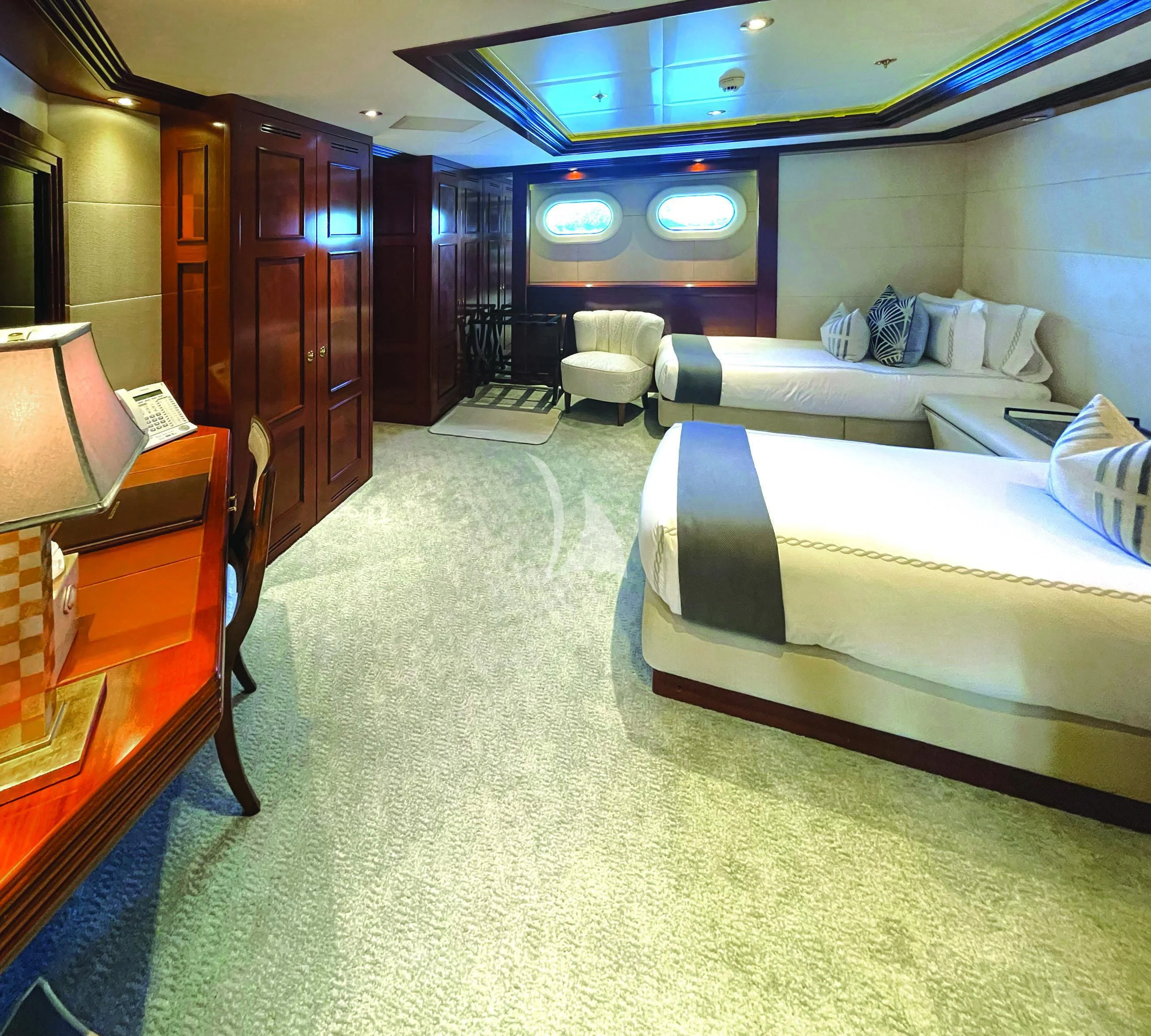 a room with a bed and a desk aboard BLUE MOON Yacht for Charter