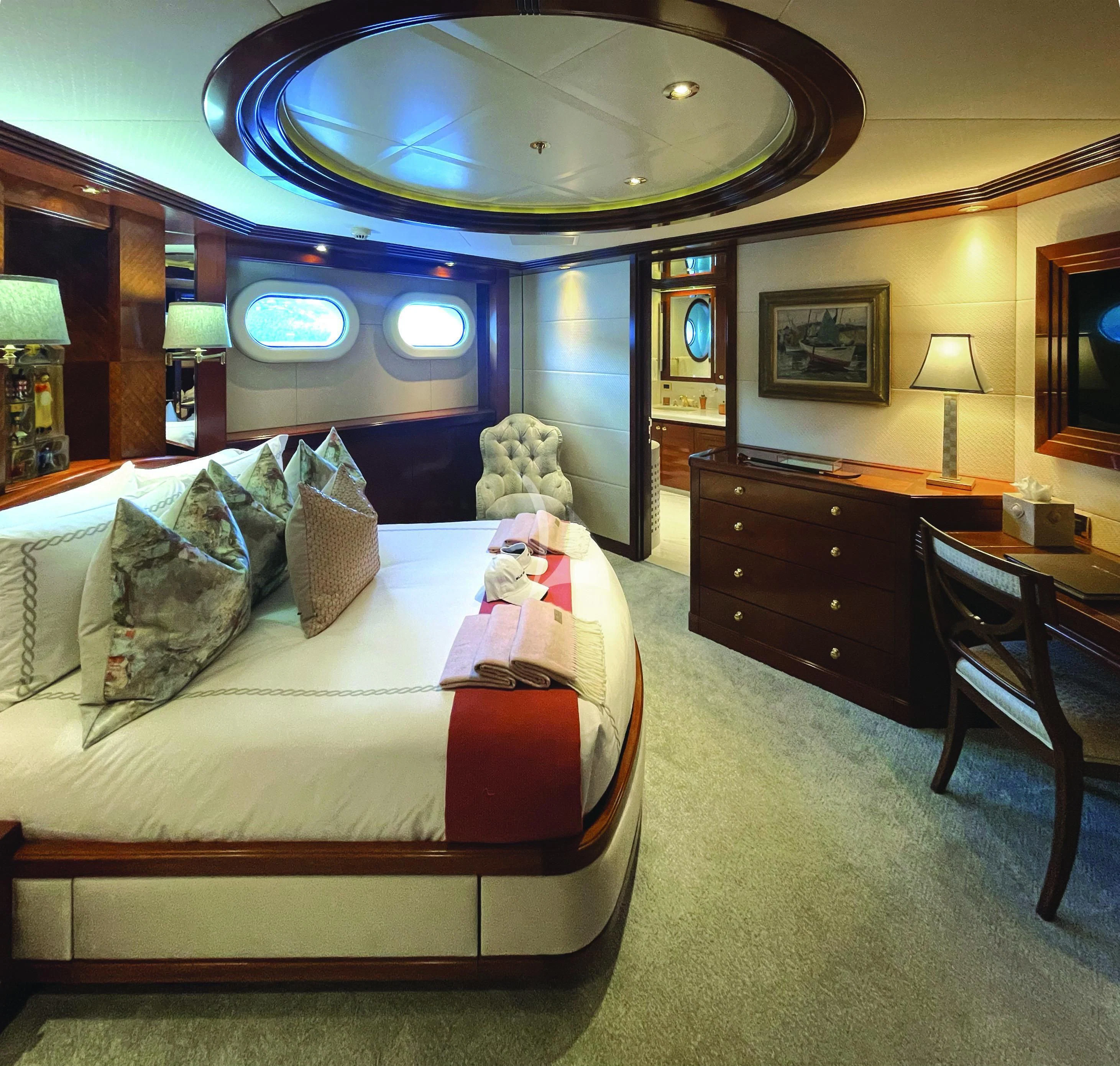 a bedroom with a large mirror above the bed aboard BLUE MOON Yacht for Charter