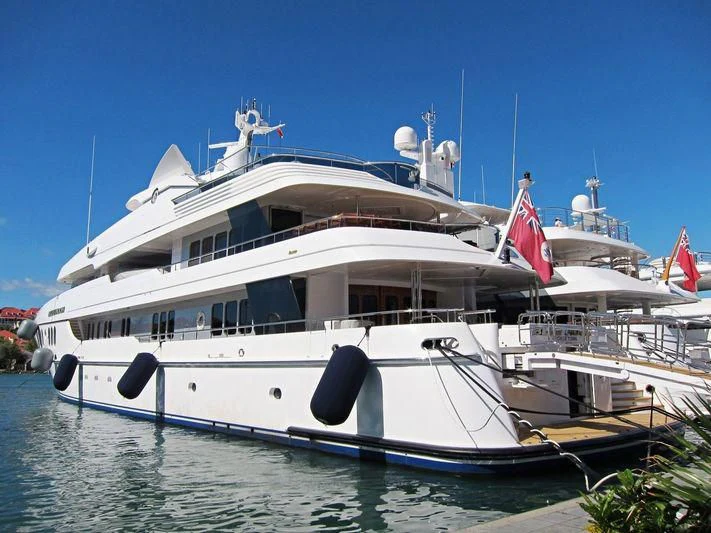 a large white boat with a flag on it aboard BLUE MOON Yacht for Charter