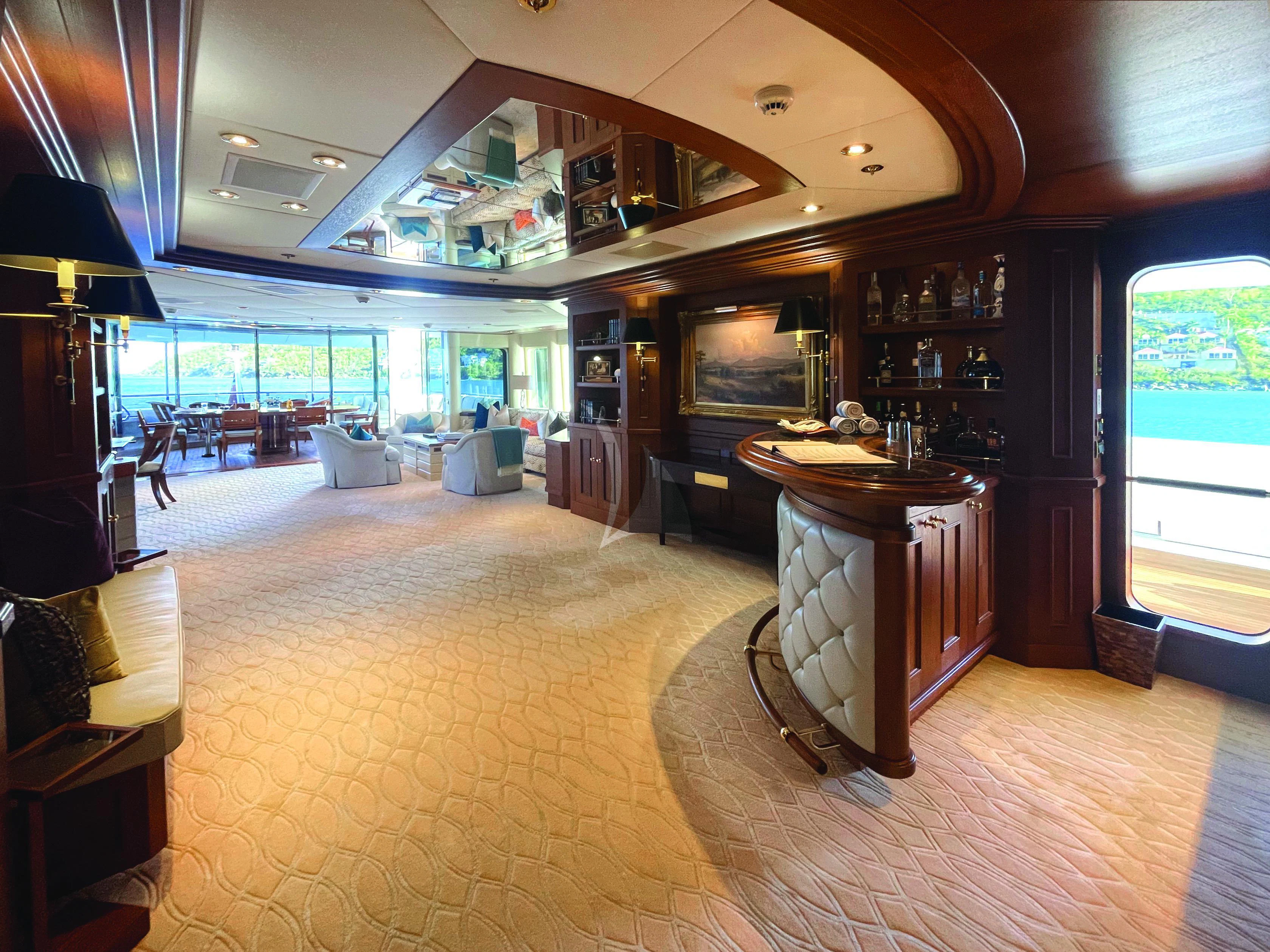 a room with a bar and a table aboard BLUE MOON Yacht for Charter