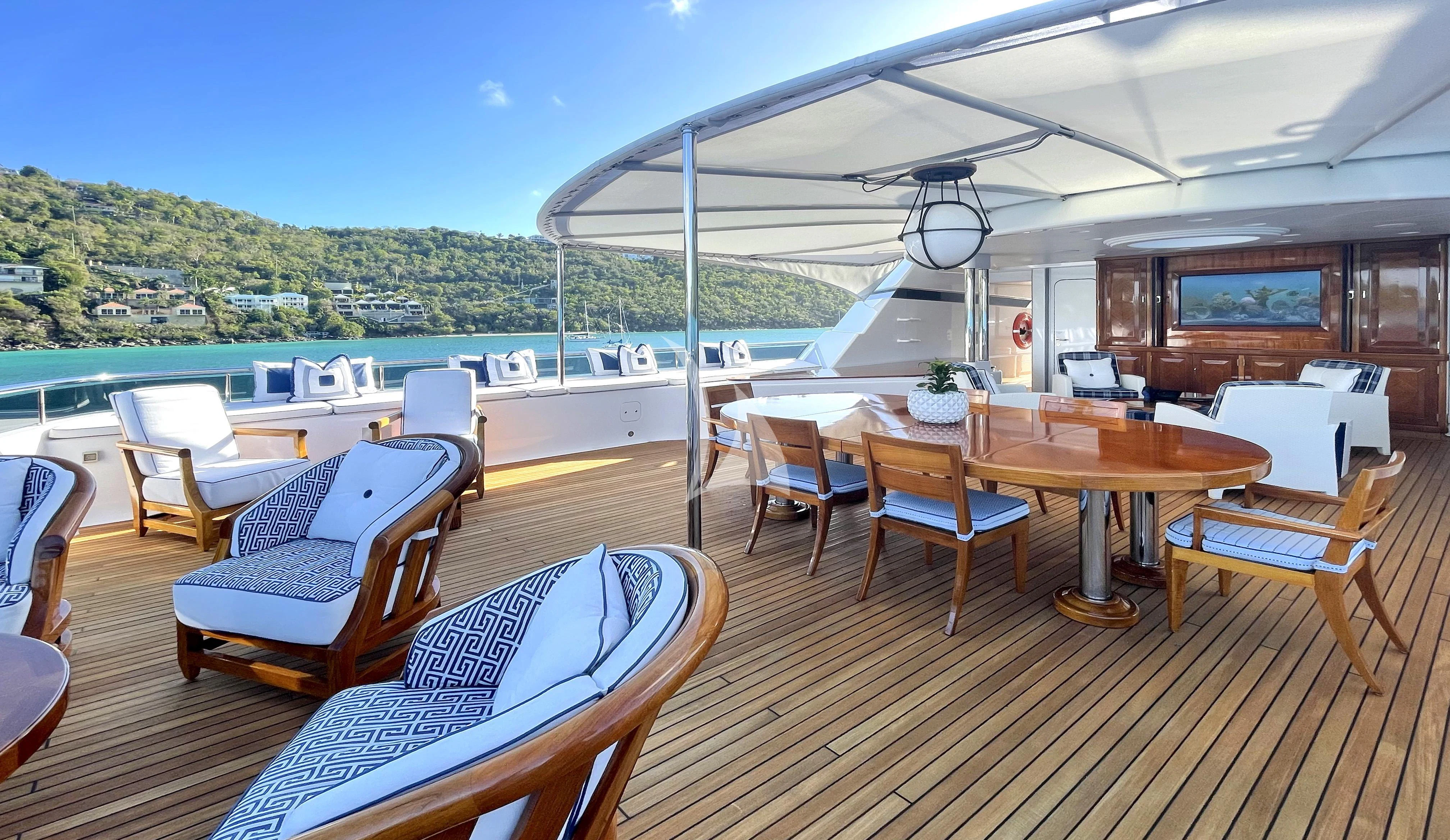 a deck with a table and chairs aboard BLUE MOON Yacht for Charter