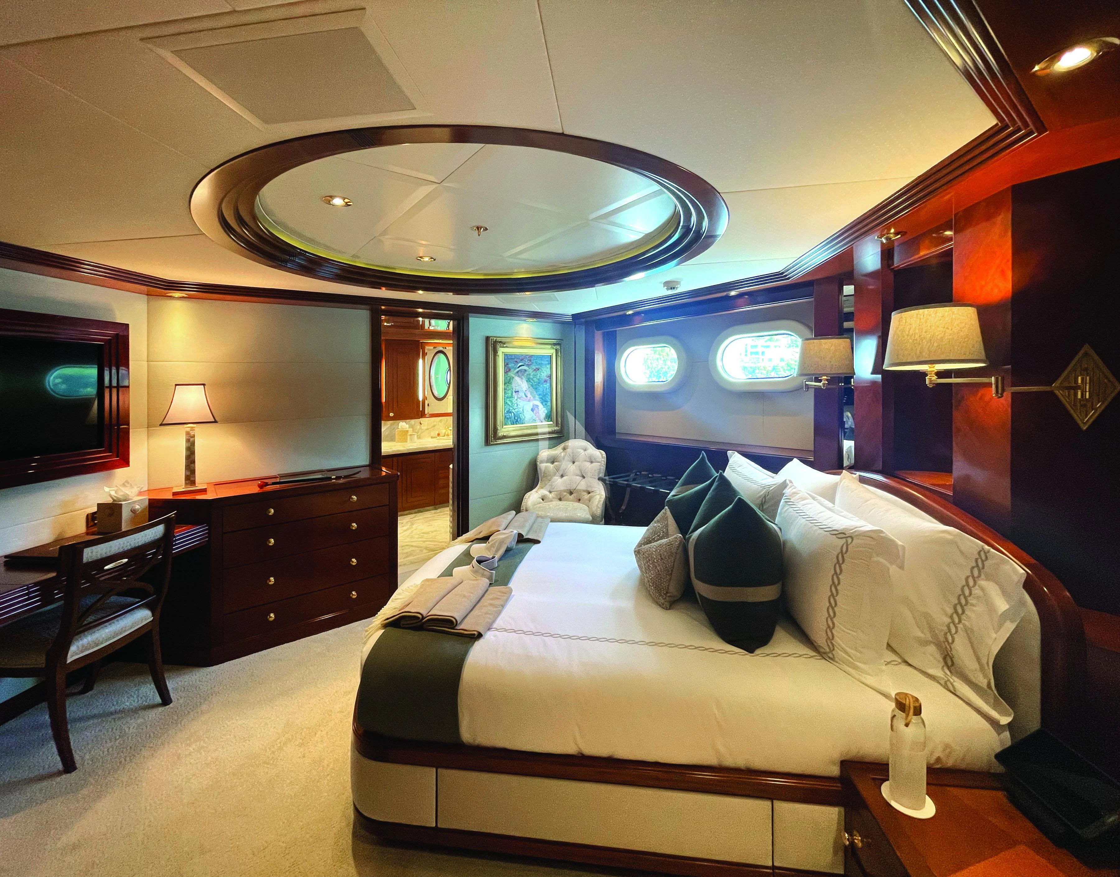 a large bedroom with a large chandelier aboard BLUE MOON Yacht for Charter