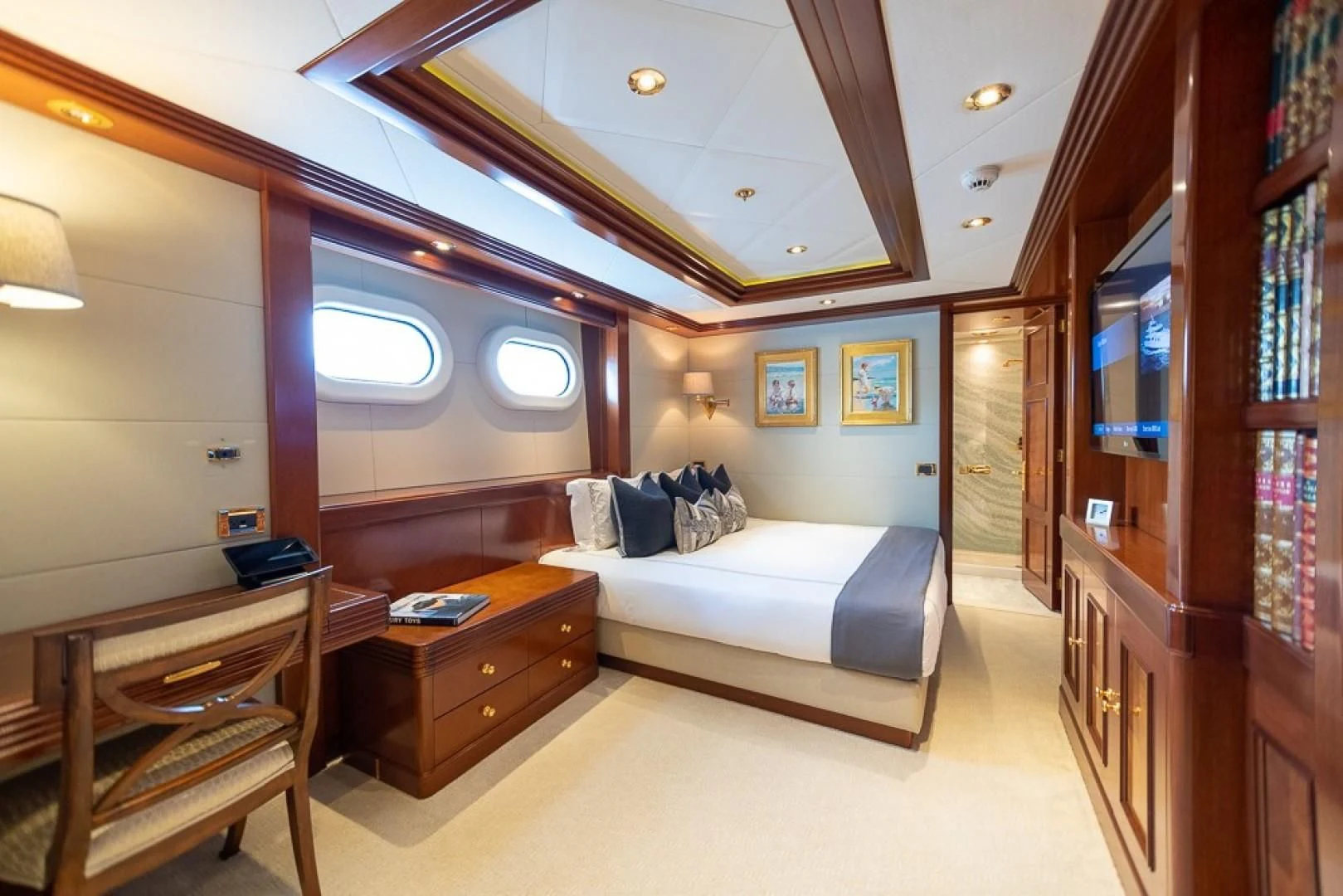 a bedroom with a bed and a desk aboard BLUE MOON Yacht for Charter