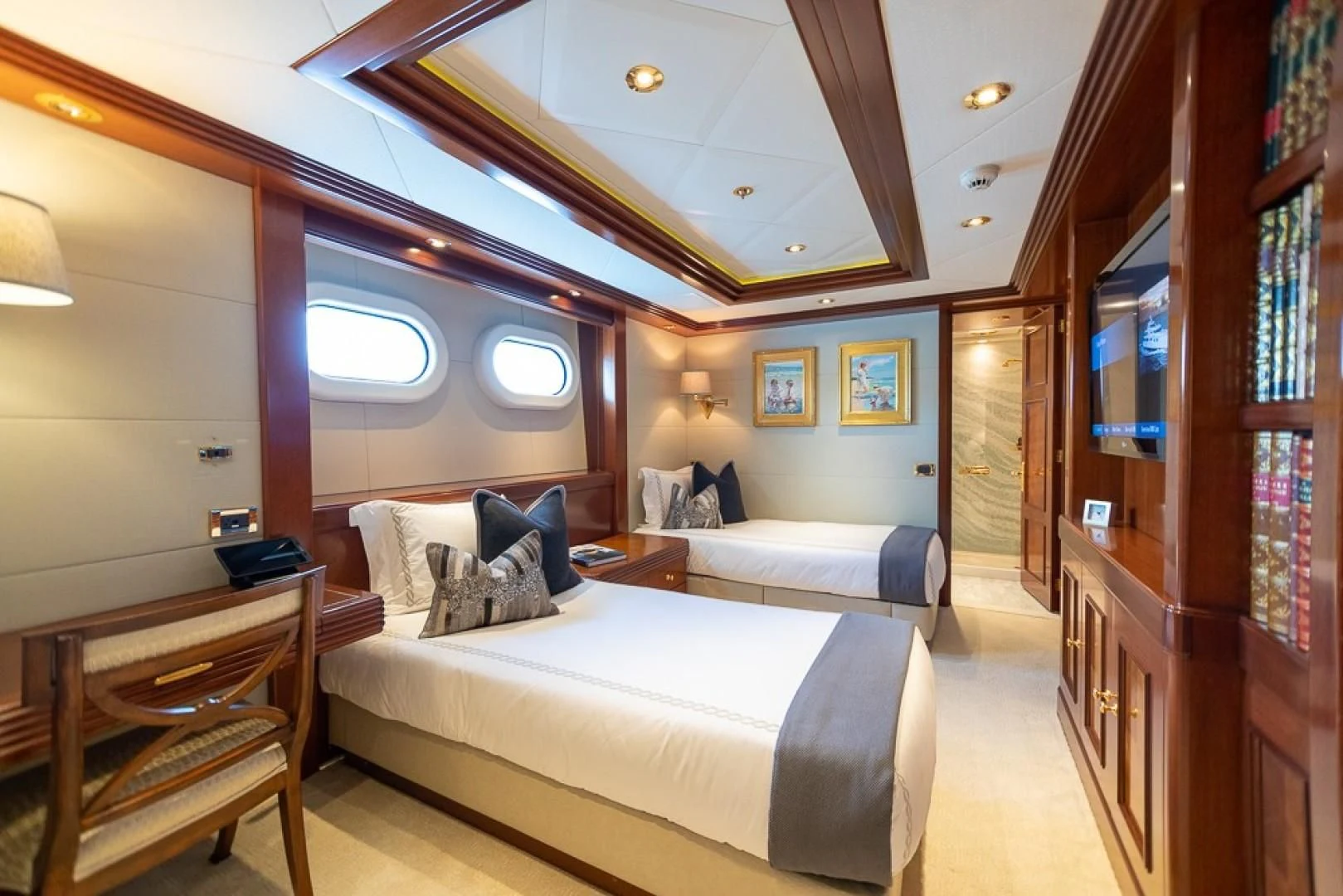 a bedroom with a bed and a desk aboard BLUE MOON Yacht for Charter