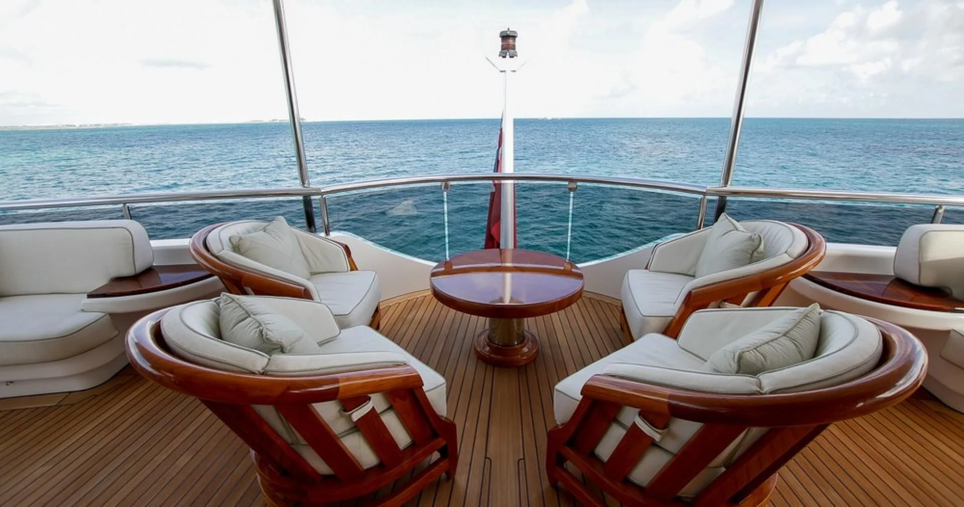 a table with chairs on it and a red pole on the side aboard BLUE MOON Yacht for Charter
