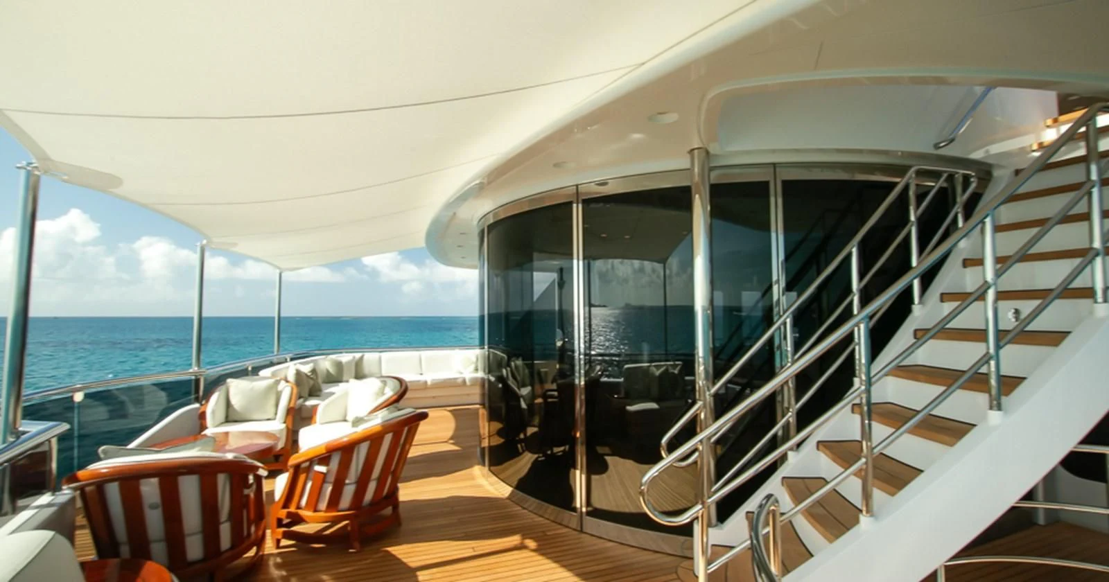 a room with a large glass door and a balcony overlooking the ocean aboard BLUE MOON Yacht for Charter