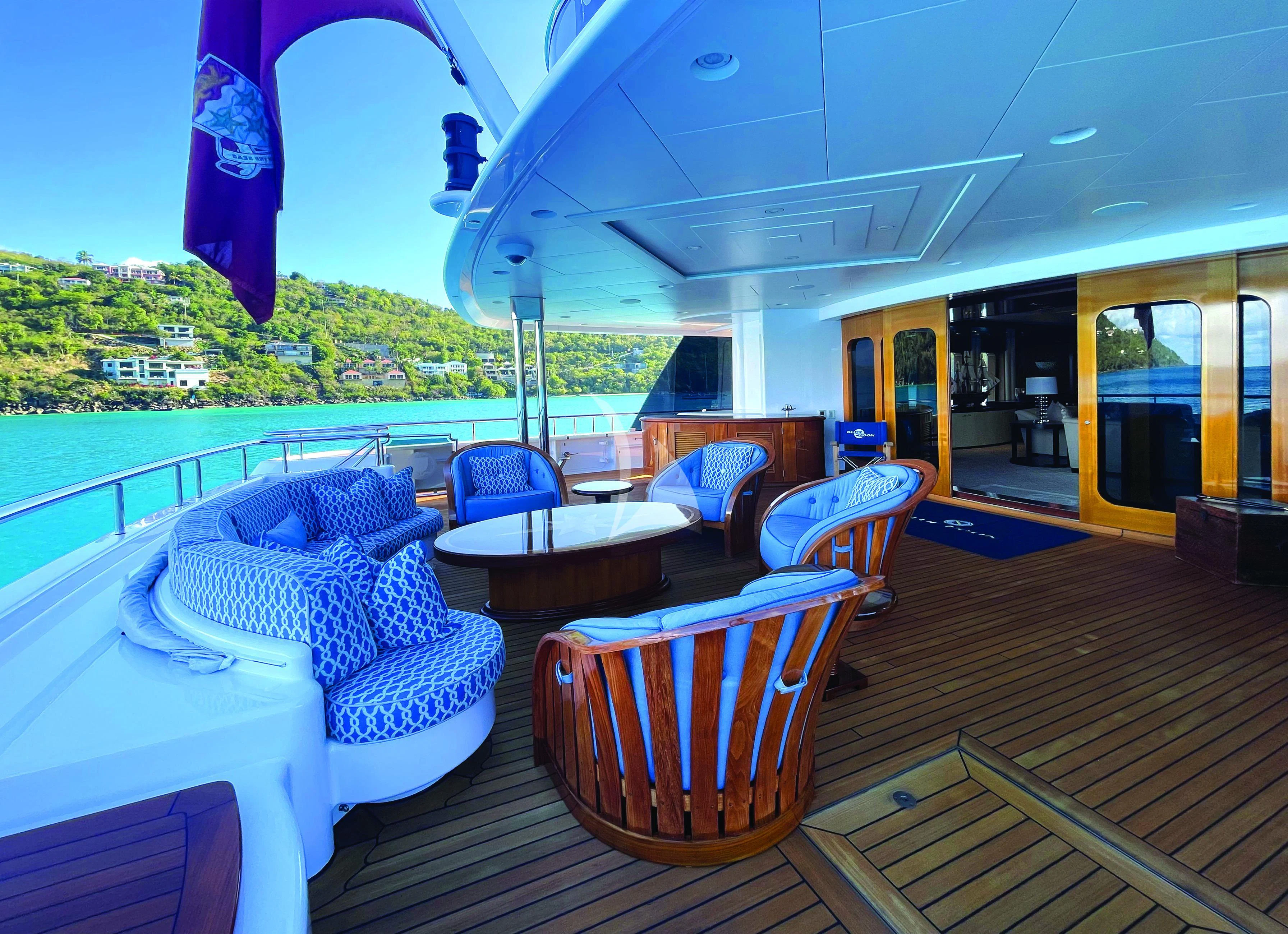 a deck with chairs and a table on it aboard BLUE MOON Yacht for Charter