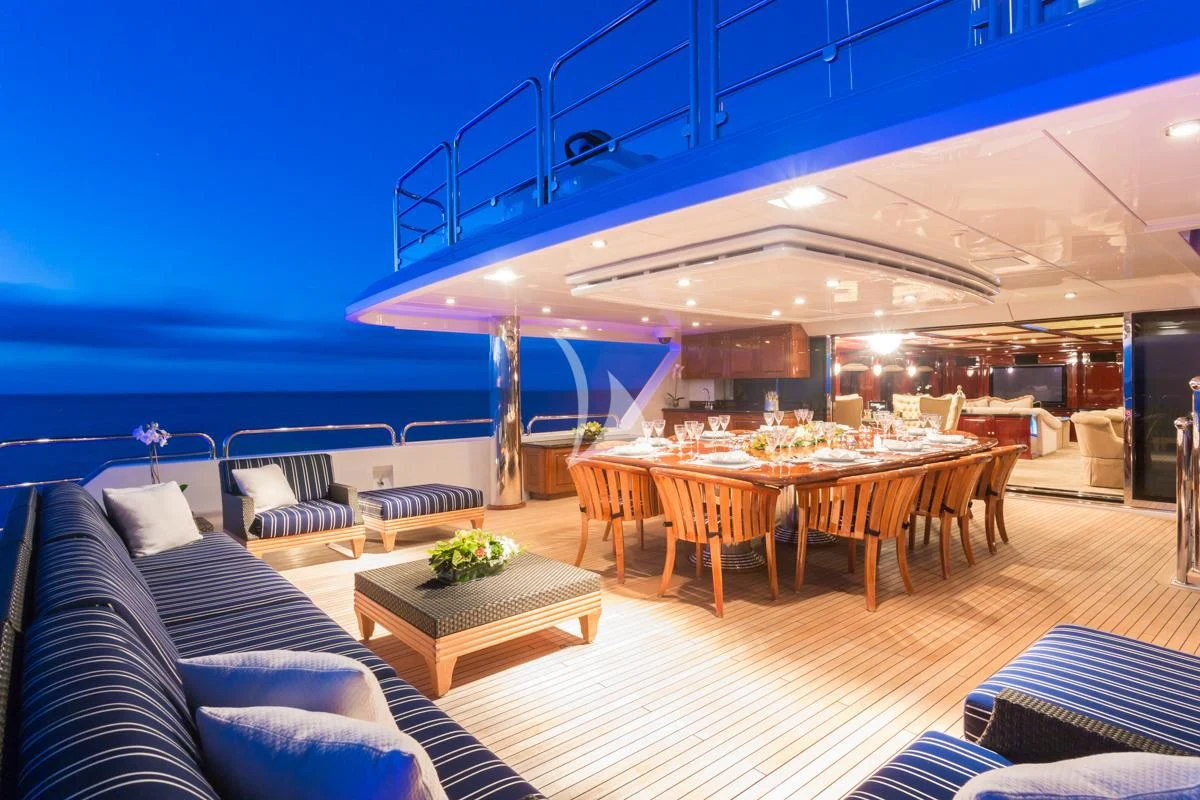 a large room with a table and chairs and a large body of water aboard LADY ELAINE Yacht for Charter
