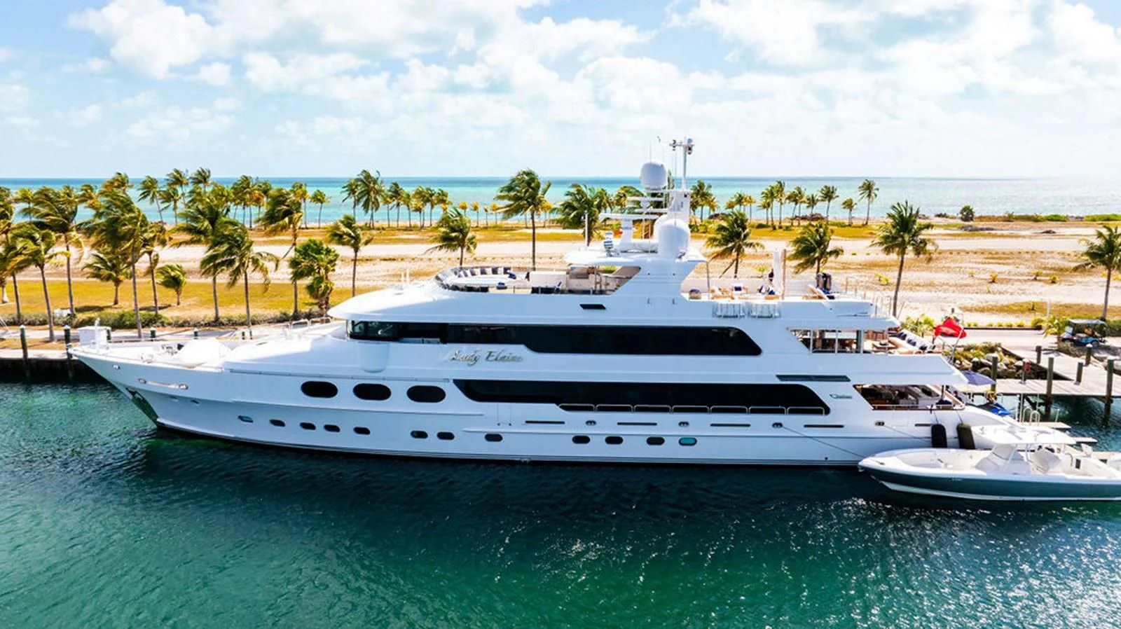 a large white yacht in a tropical bay aboard LADY ELAINE Yacht for Charter