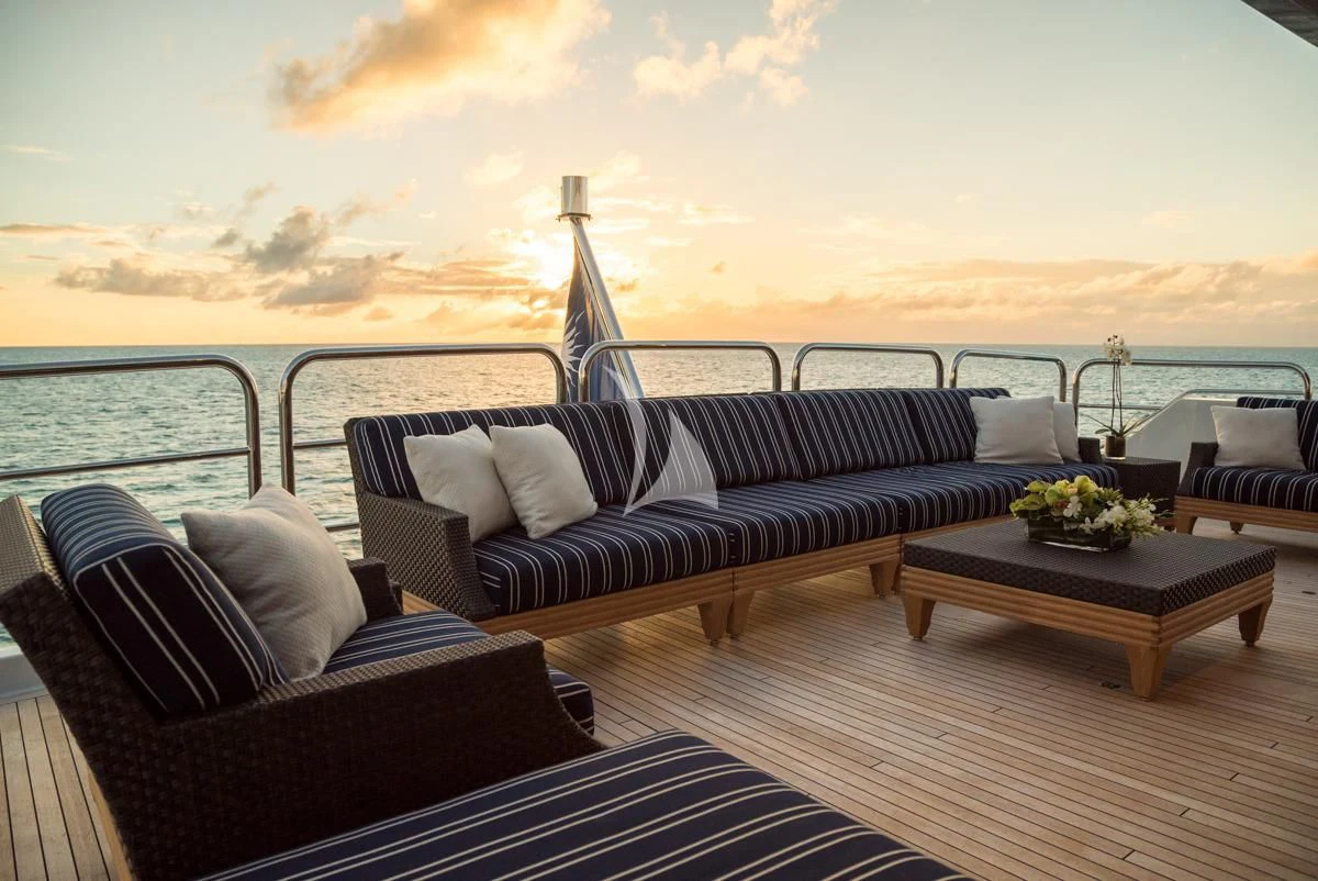 a living room with a large body of water and a large boat in the background aboard LADY ELAINE Yacht for Charter