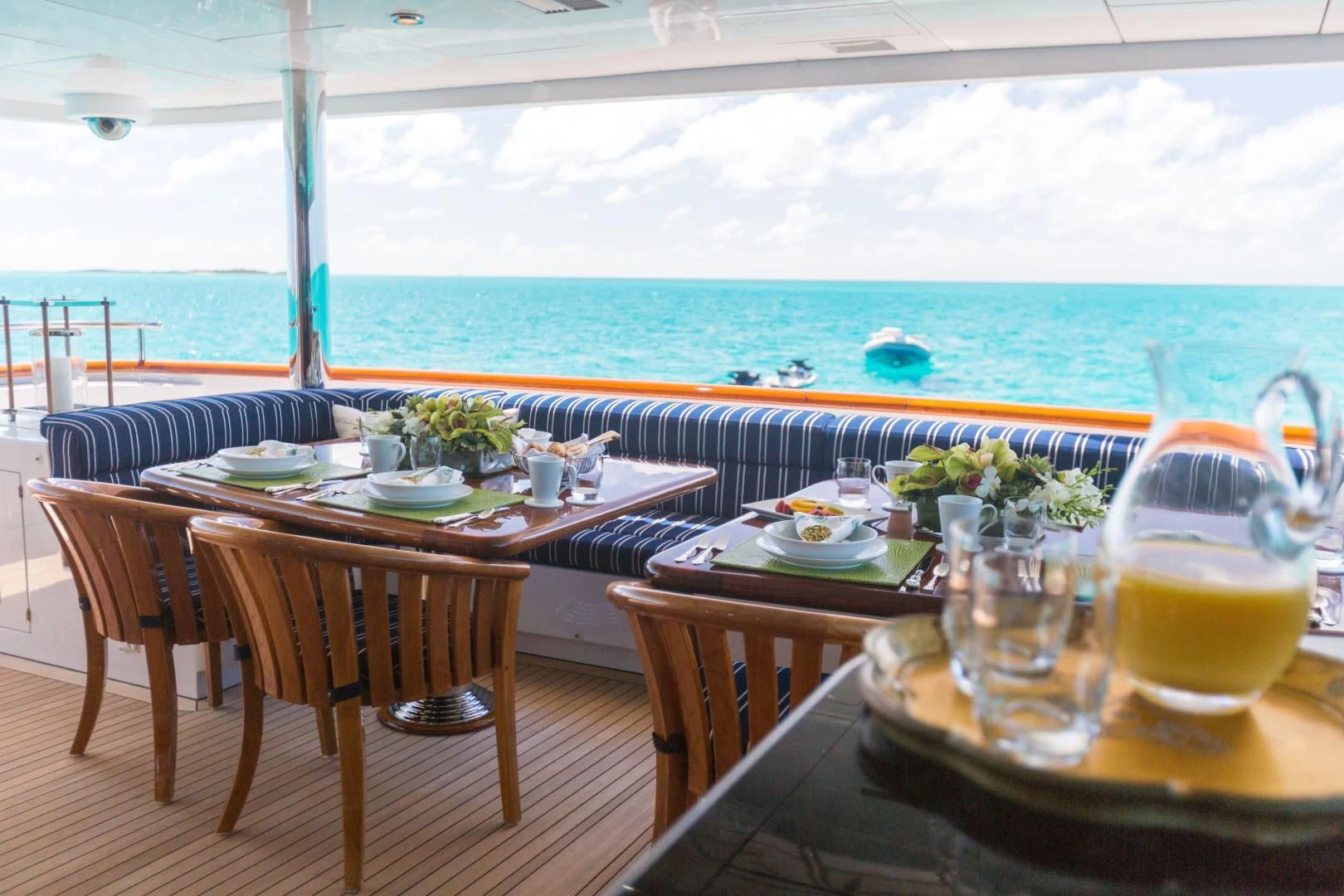 a table set for a meal on a balcony overlooking the ocean aboard LADY ELAINE Yacht for Charter