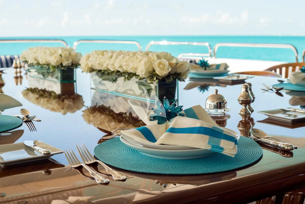 a table with a plate of food and a flower on it aboard LADY ELAINE Yacht for Charter