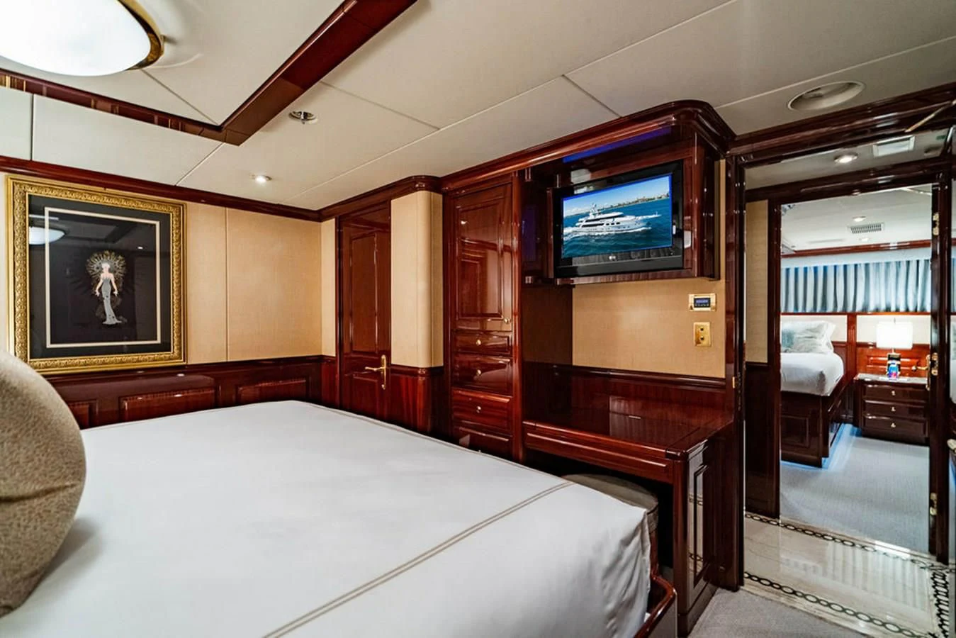 a hotel room with a bed and tv aboard LADY ELAINE Yacht for Charter