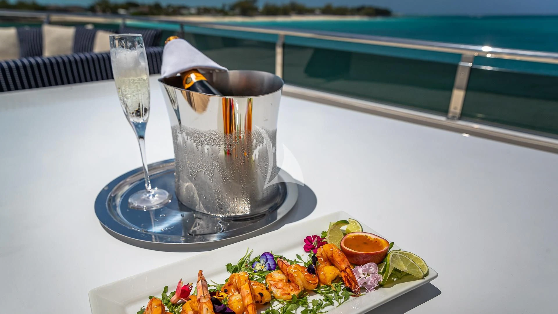 a glass of champagne and a plate of food on a table aboard LADY ELAINE Yacht for Charter