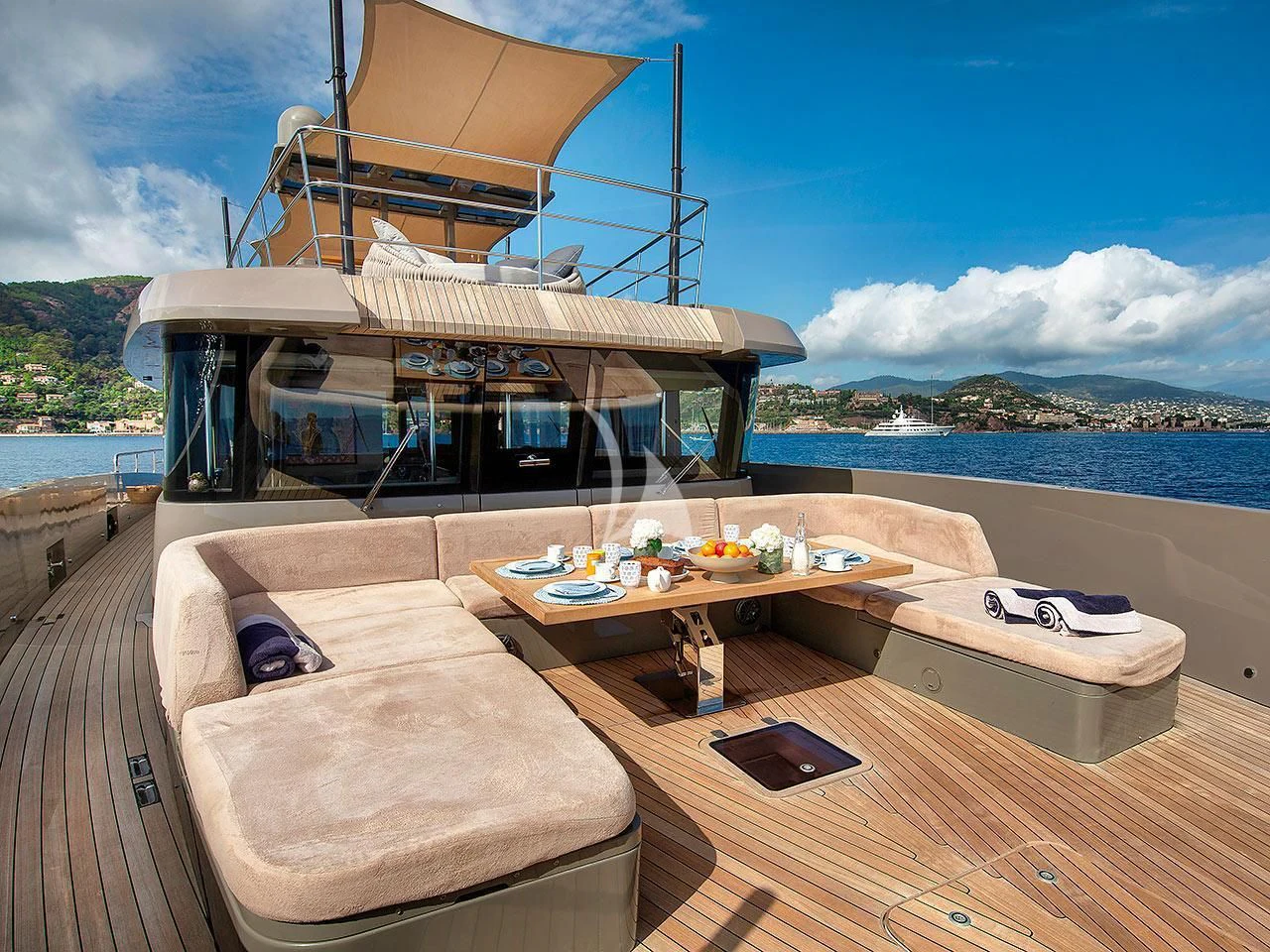 a deck with a table and a bed on it aboard KOKONUT'S WALLY Yacht for Sale
