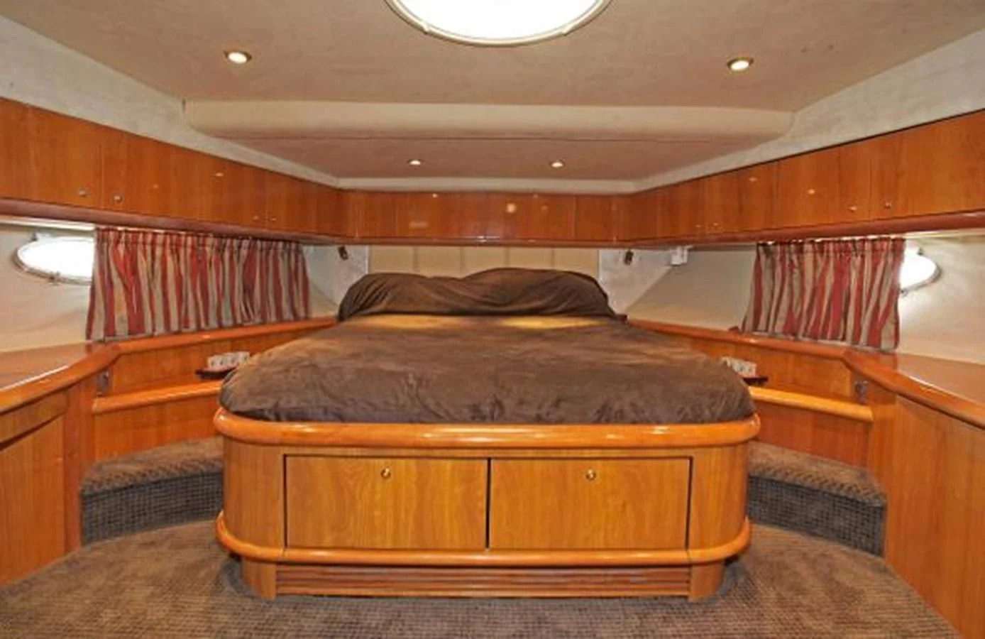 a room with a bed and a wood cabinet aboard H2 Yacht for Sale