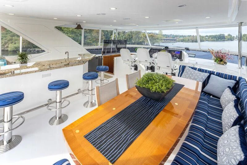 a room with a table chairs and plants aboard SPILL POINT Yacht for Sale