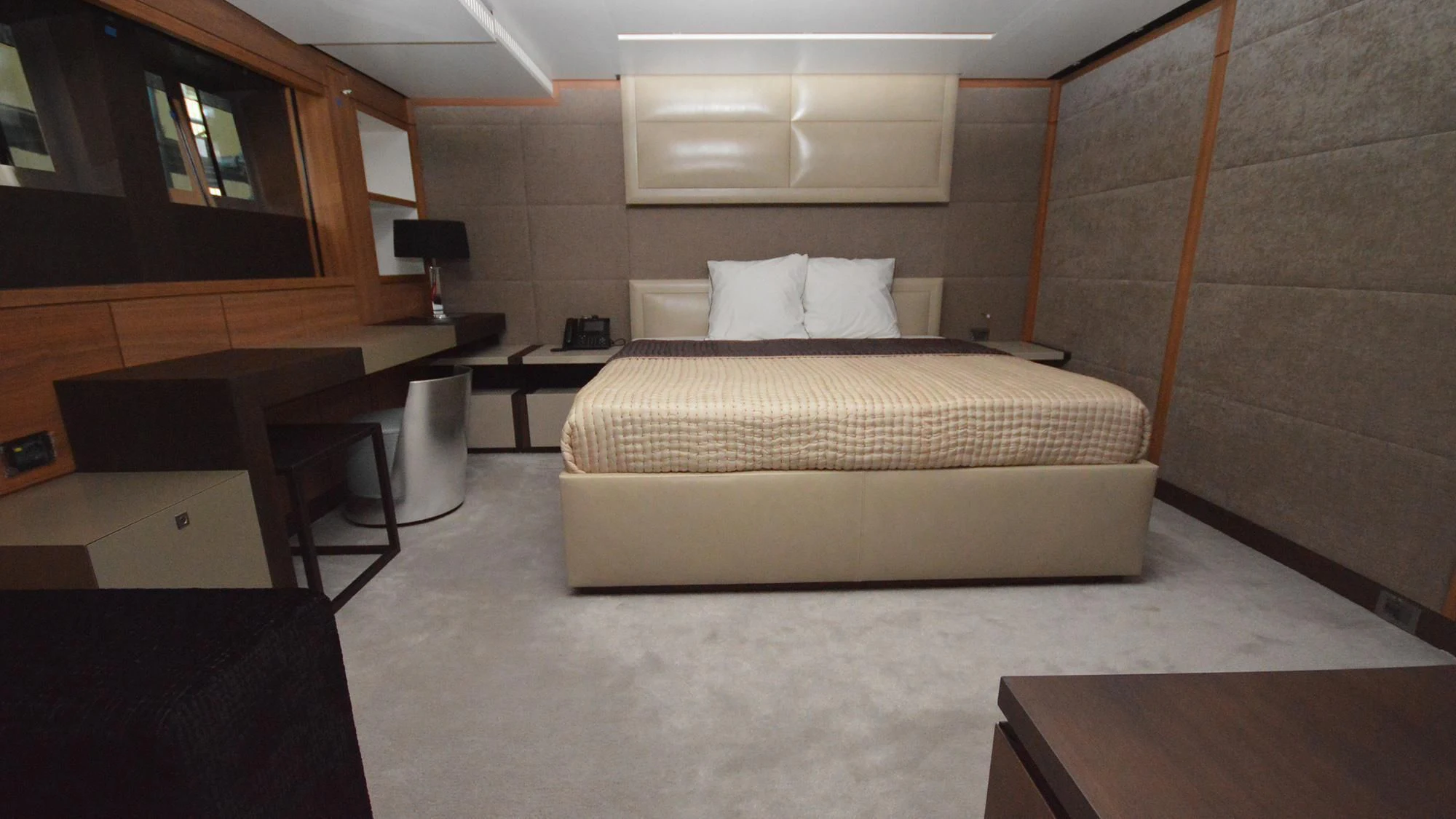 a room with a bed and desk aboard NAVIS ONE Yacht for Charter