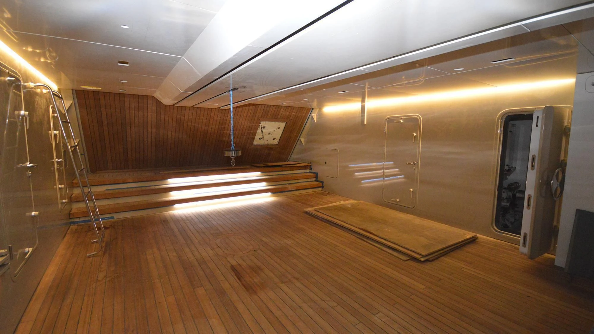 a room with a wood floor and a staircase aboard NAVIS ONE Yacht for Charter