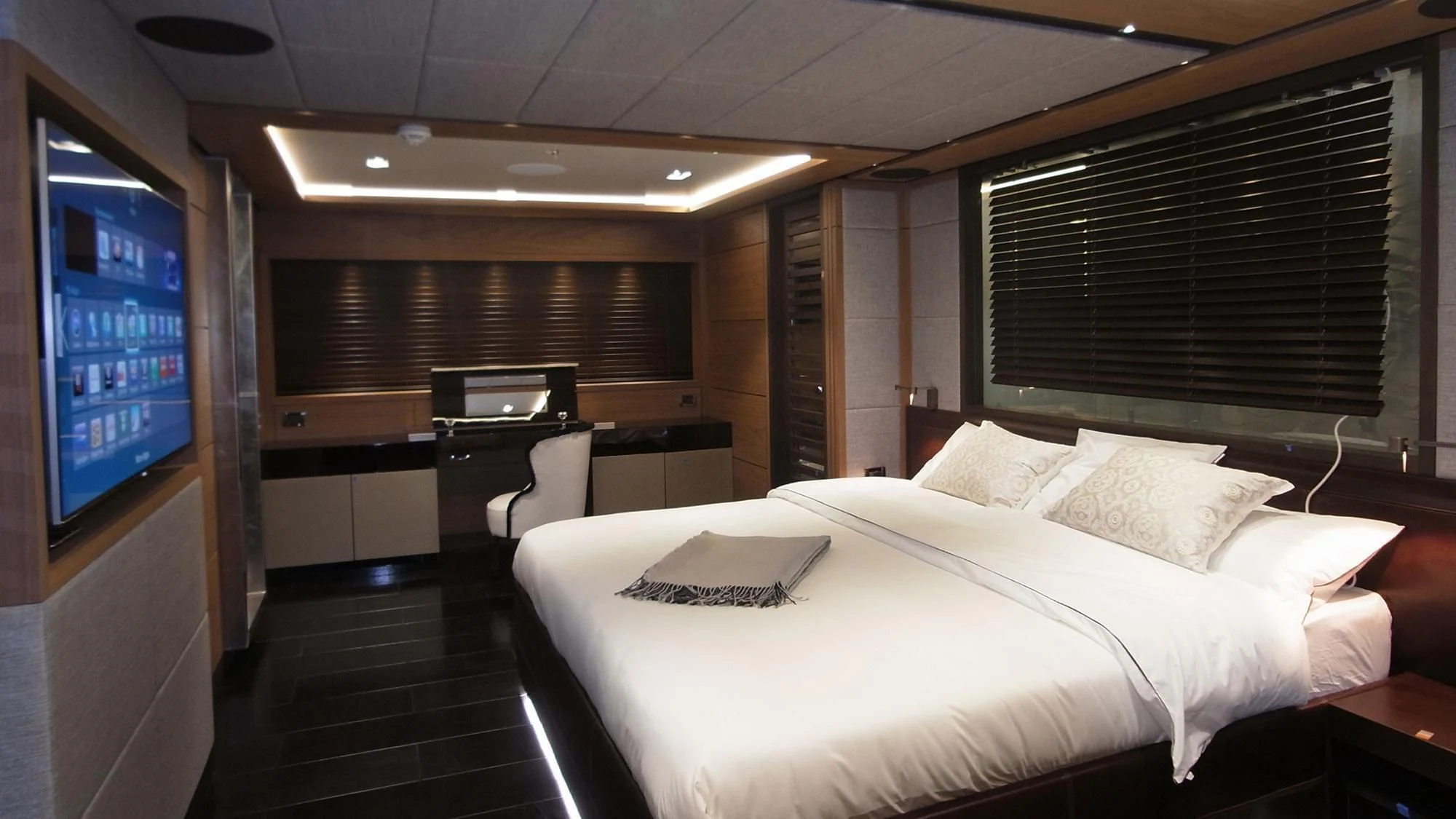 a room with a bed and desk aboard NAVIS ONE Yacht for Charter