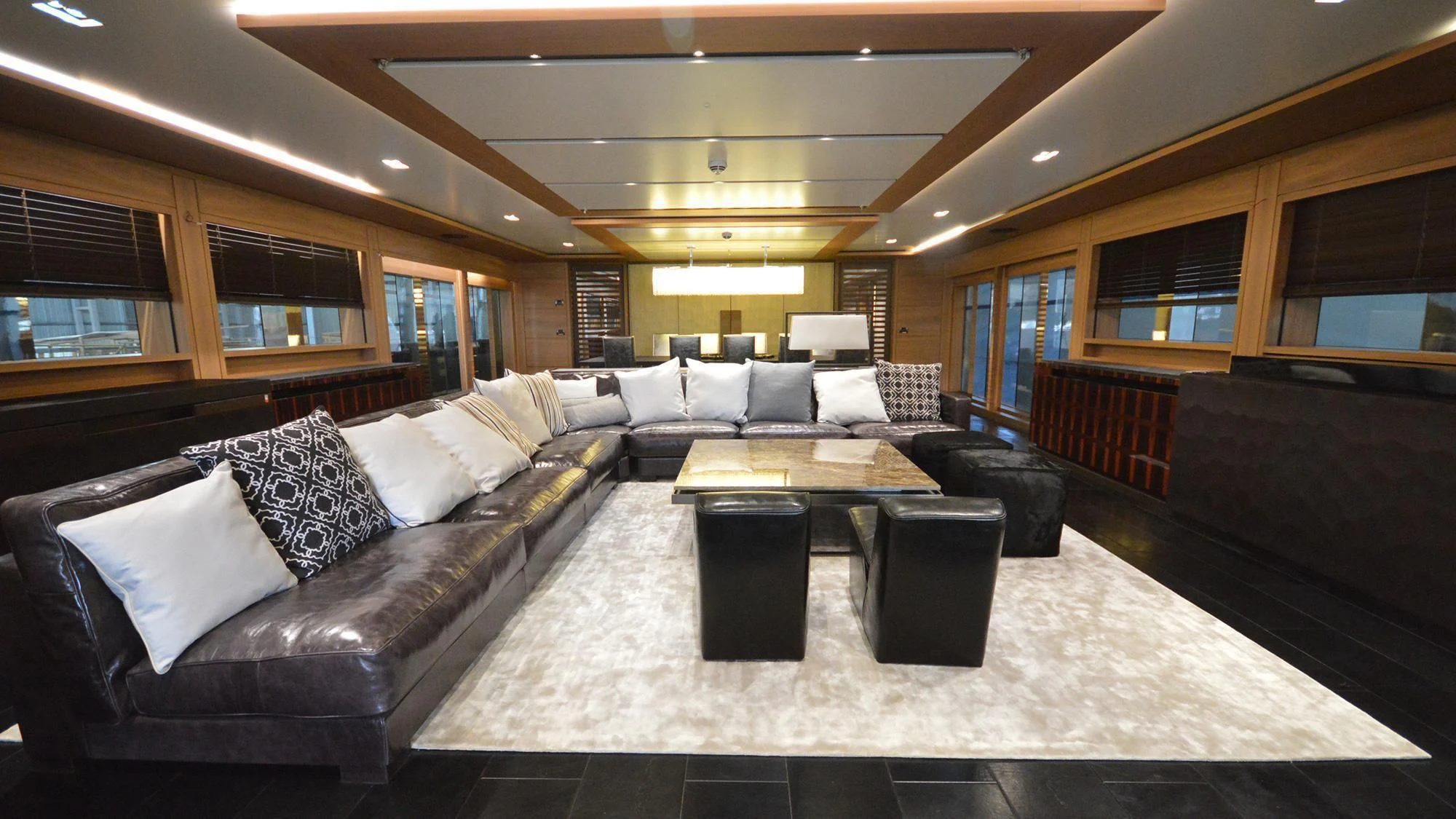 a large living room with a large couch and a large window aboard NAVIS ONE Yacht for Charter