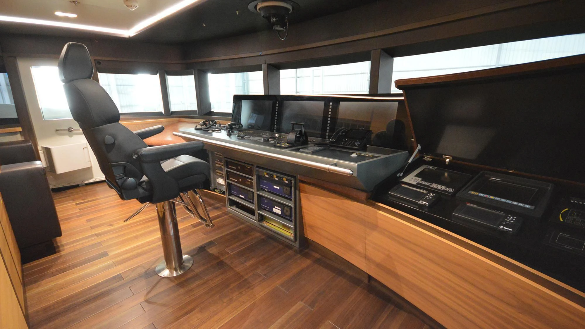 a room with a large black chair and a black chair aboard NAVIS ONE Yacht for Charter