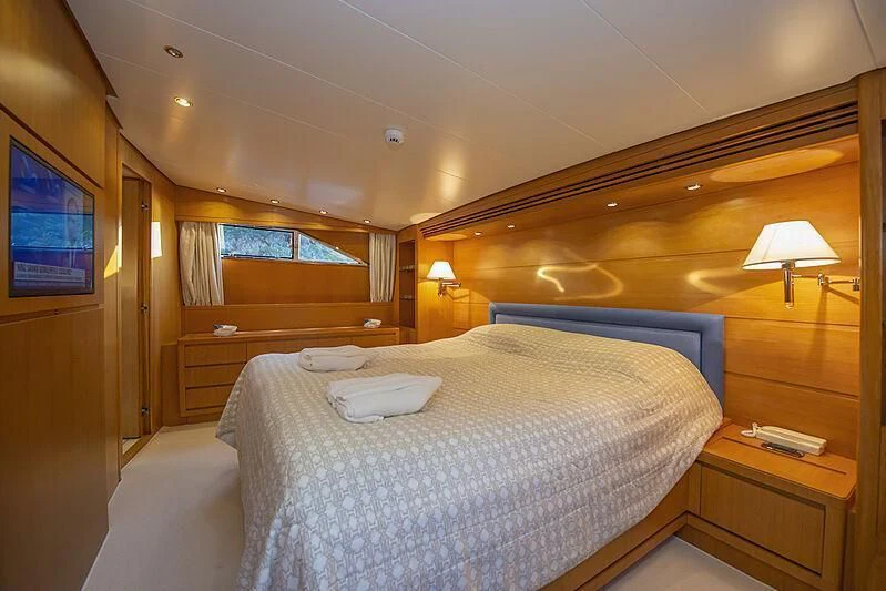 a bedroom with a bed and a television aboard LADY EMESA Yacht for Sale