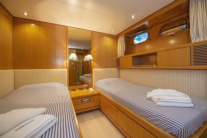 a room with beds and a mirror aboard LADY EMESA Yacht for Sale