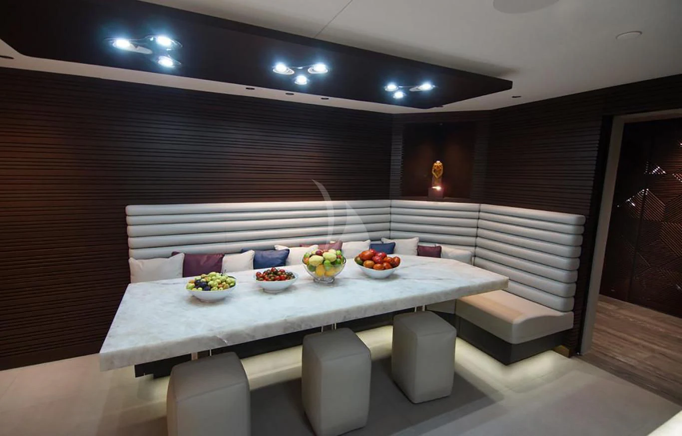 a table with chairs and a couch aboard BABA'S Yacht for Sale