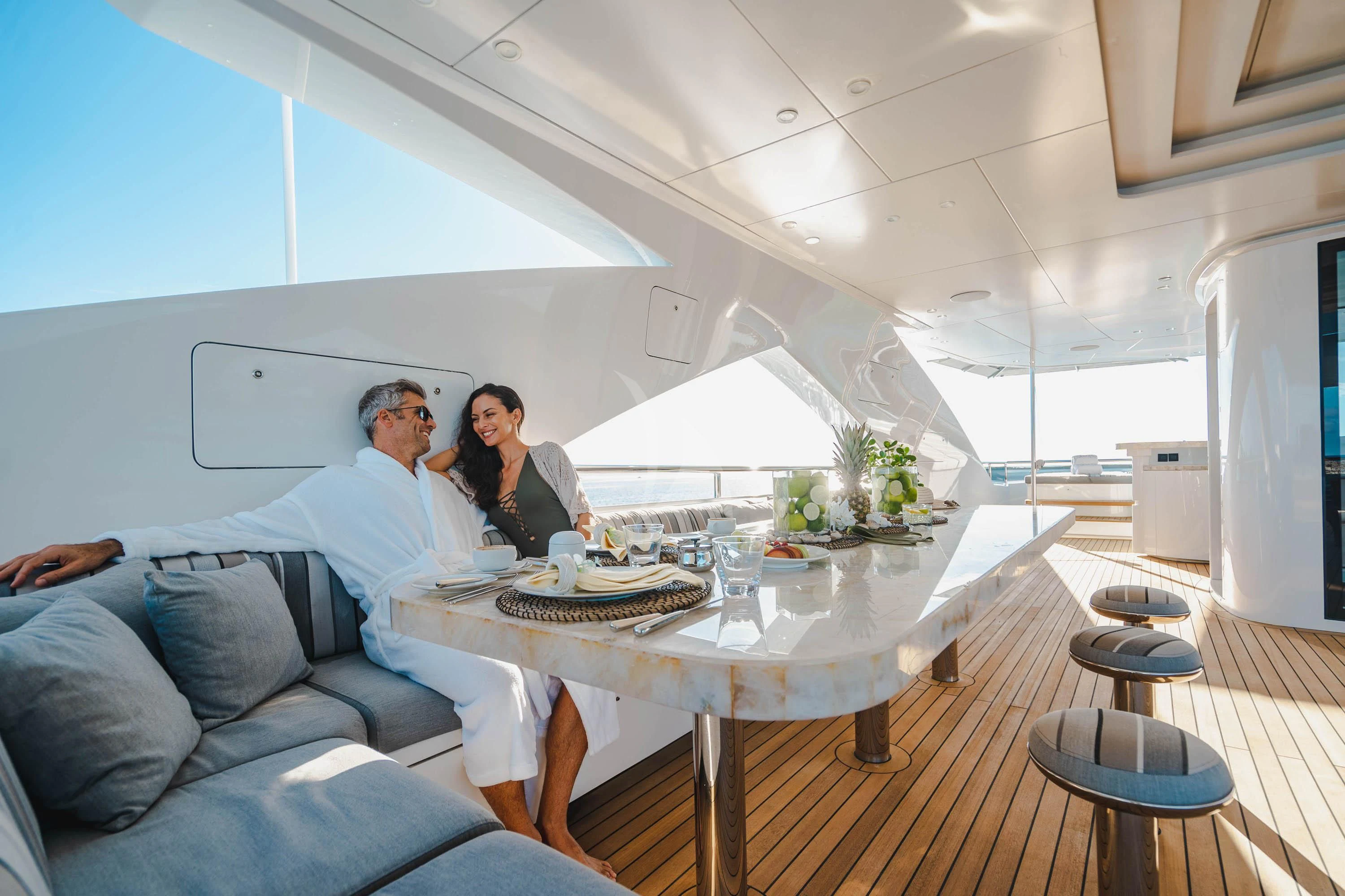 a man and a woman sitting at a table in a room aboard BABA'S Yacht for Sale