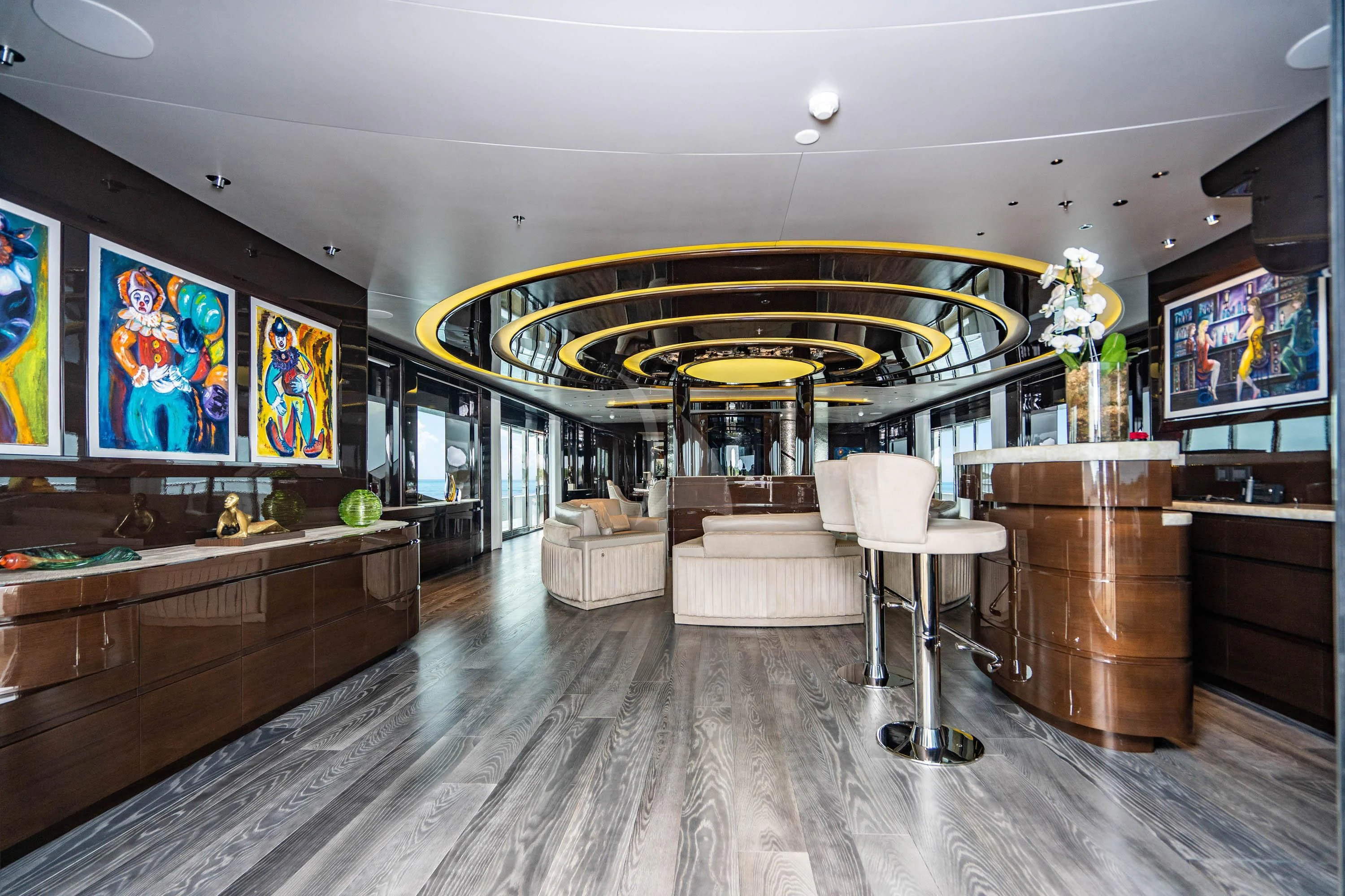 a room with a wood floor and a large window with art on the wall aboard BABA'S Yacht for Sale