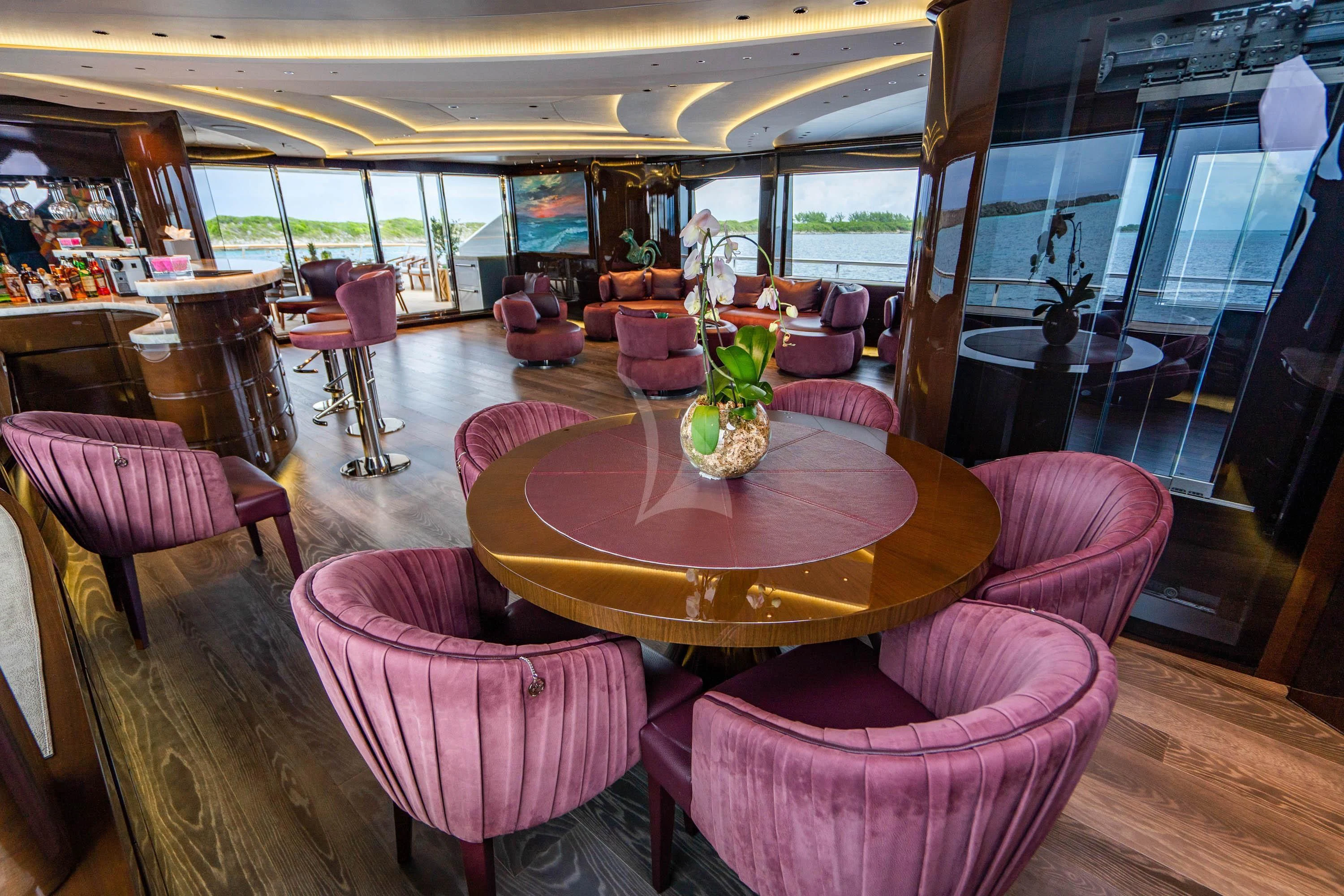 a room with a table chairs and a plant in it aboard BABA'S Yacht for Sale