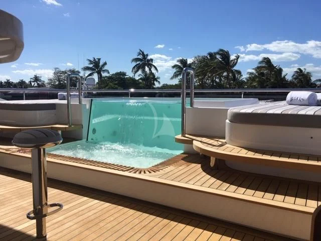 a pool with a deck and a deck and trees in the background aboard BABA'S Yacht for Sale