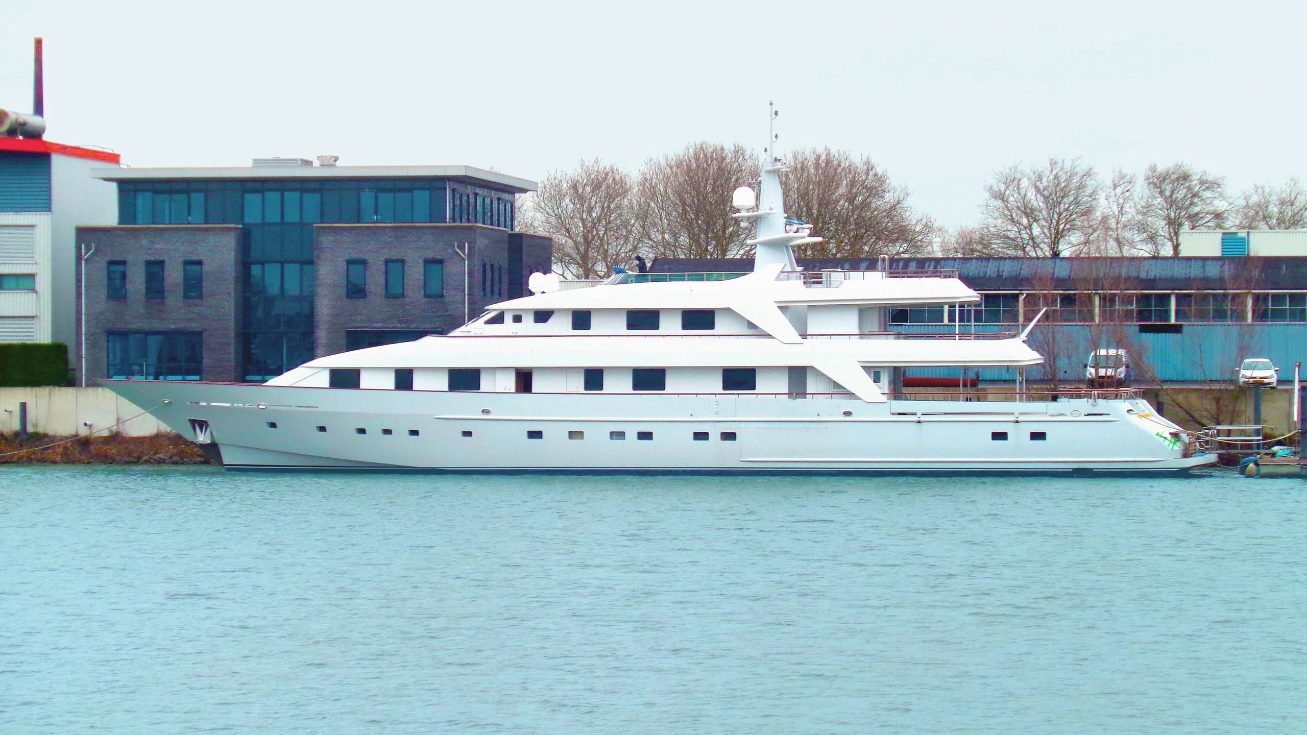 a large white boat in a harbor aboard ANNA J Yacht for Sale