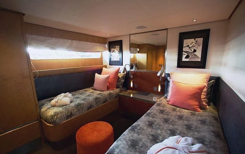 a bedroom with a bed and a couch aboard CURIOSITY Yacht for Sale