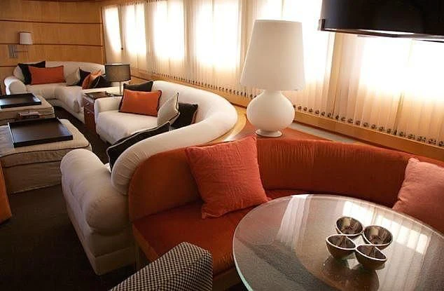 a living room with a couch and a table aboard CURIOSITY Yacht for Sale