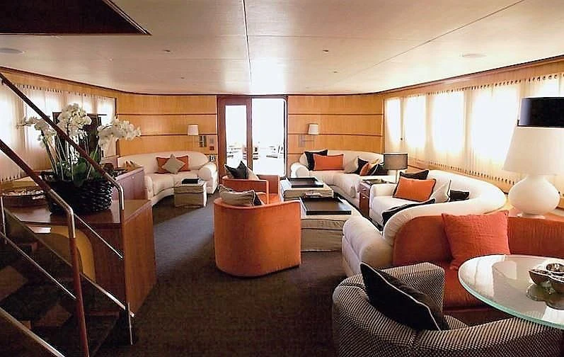 a living room with a couch and a table aboard CURIOSITY Yacht for Sale