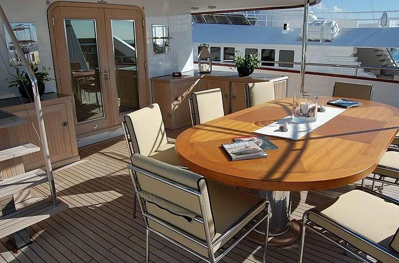 a table with chairs around it aboard CURIOSITY Yacht for Sale