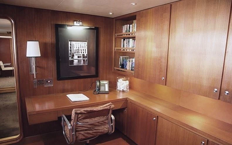 a chair and a desk in a room aboard CURIOSITY Yacht for Sale