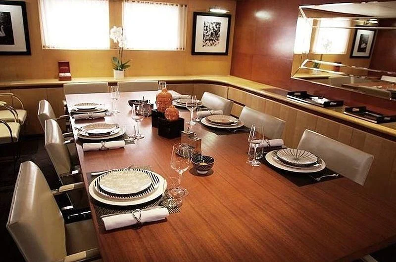 a table with plates and glasses aboard CURIOSITY Yacht for Sale