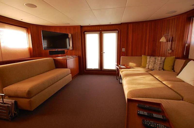 a living room with a couch and a tv aboard CURIOSITY Yacht for Sale