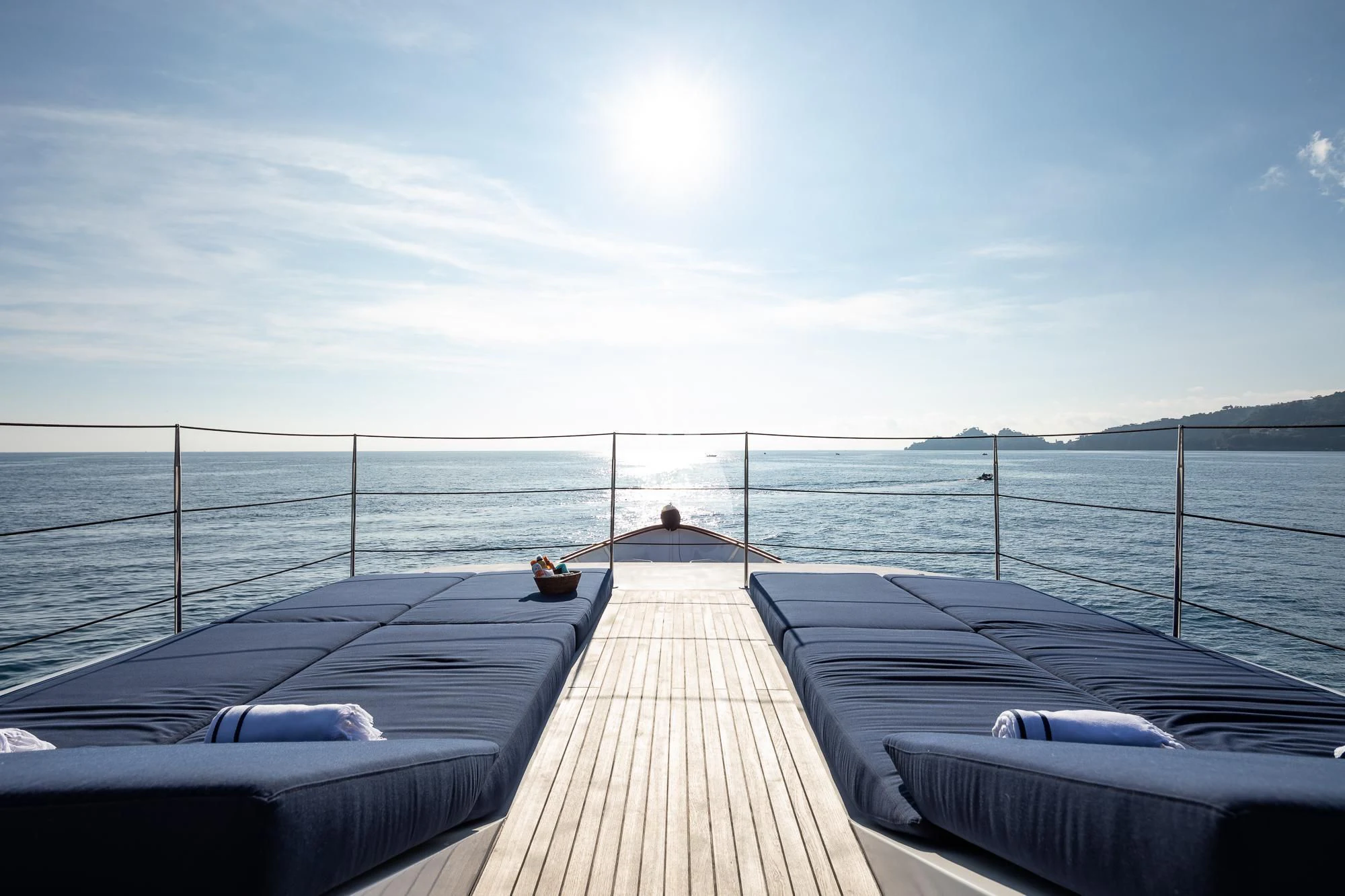 a deck with a view of the ocean and a beach aboard CURIOSITY Yacht for Sale