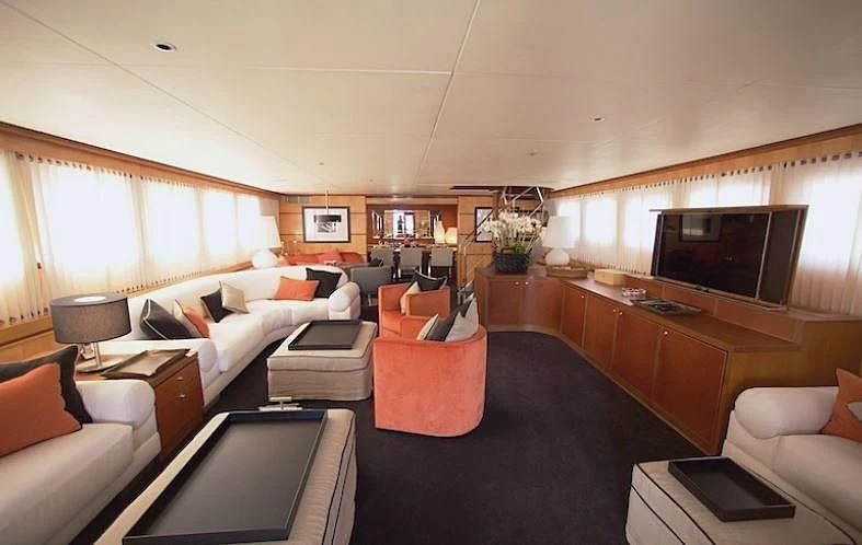 a living room with a large black rug and a large television aboard CURIOSITY Yacht for Sale