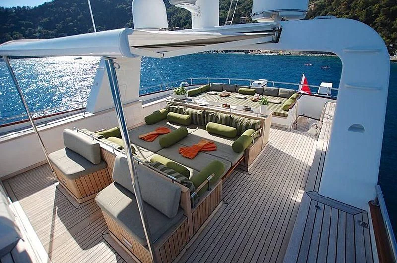 a deck with a pool and a deck with chairs and a table aboard CURIOSITY Yacht for Sale