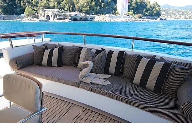 a couch on a deck overlooking a body of water aboard CURIOSITY Yacht for Sale